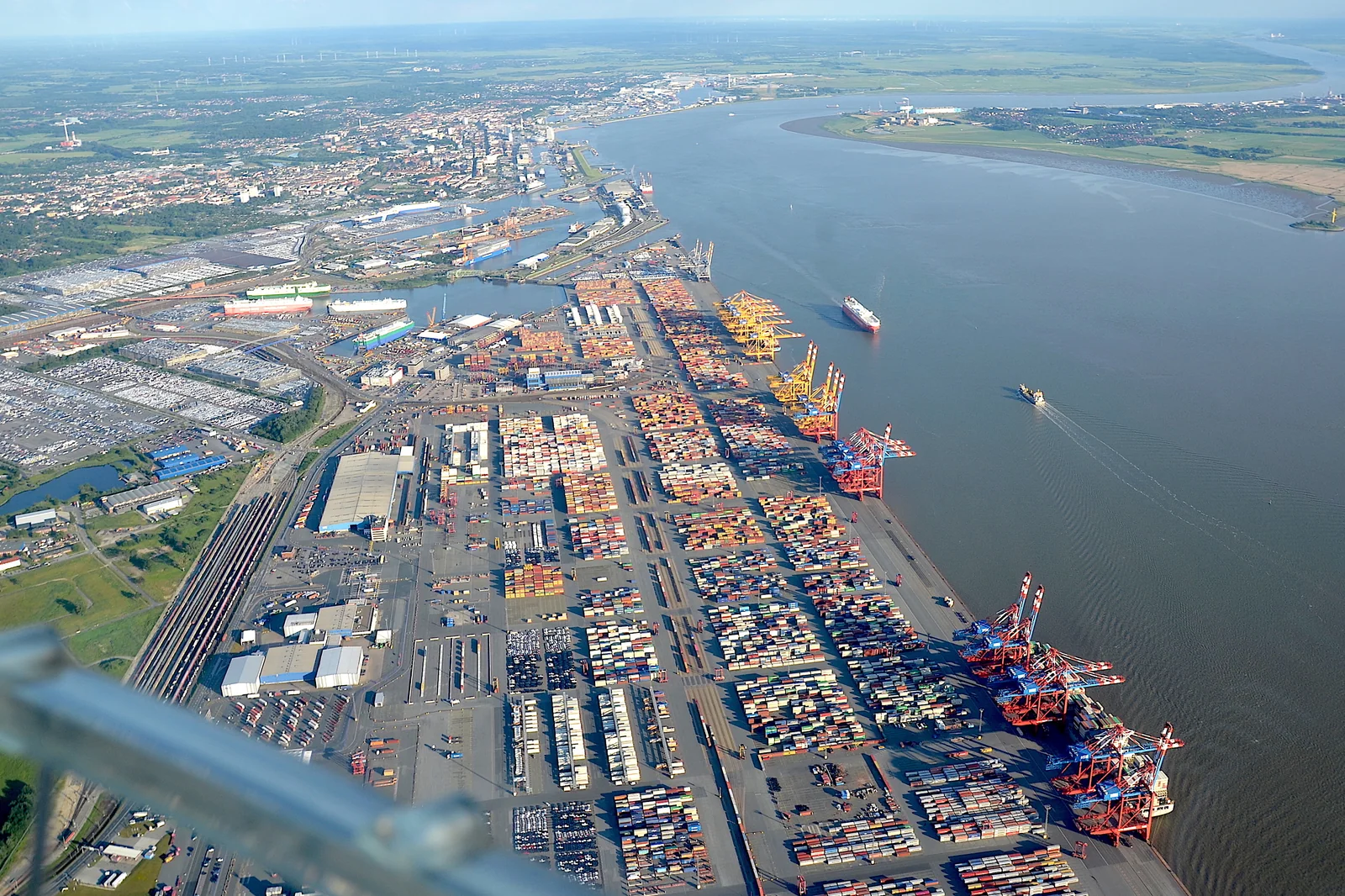 Aerial view of Bremerhaven port with vehicle storage areas, container terminals and cargo vessels